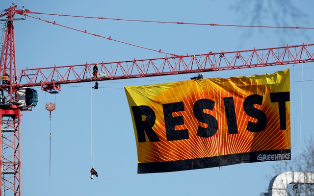 A banner reading “RESIST” hangs off a crane near the White House in Washington, D.C.