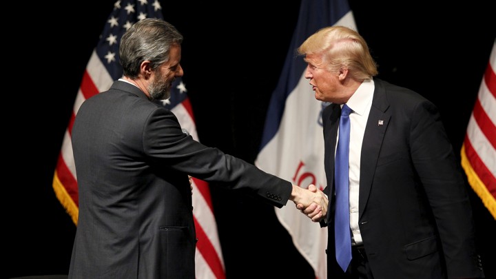 Falwell, left, smiles as he shakes hands with Trump, who appears to be mid-sentence.