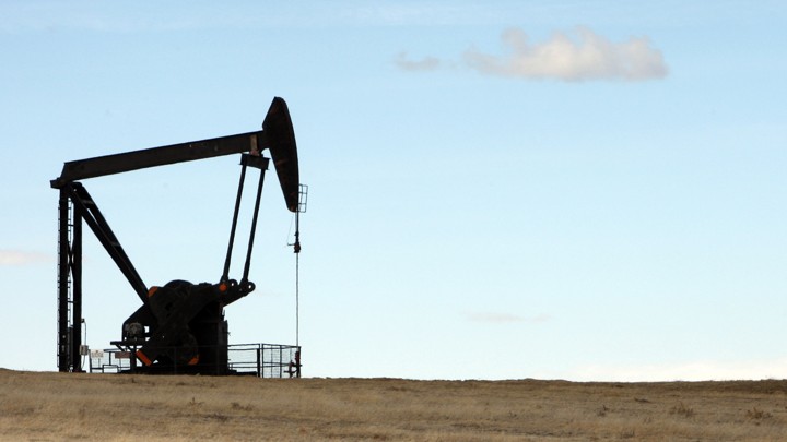 A crane-like machine drills into a field for oil