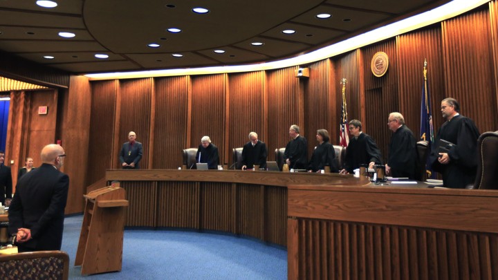 Justices in robes stand in a courtroom.