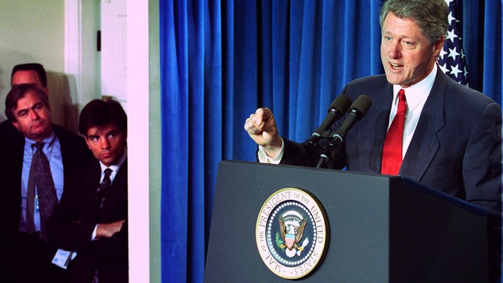Mack McLarty, David Gergen, Sandy Berger, and George Stephanopoulos watch Bill Clinton at an October 1993 news conference.