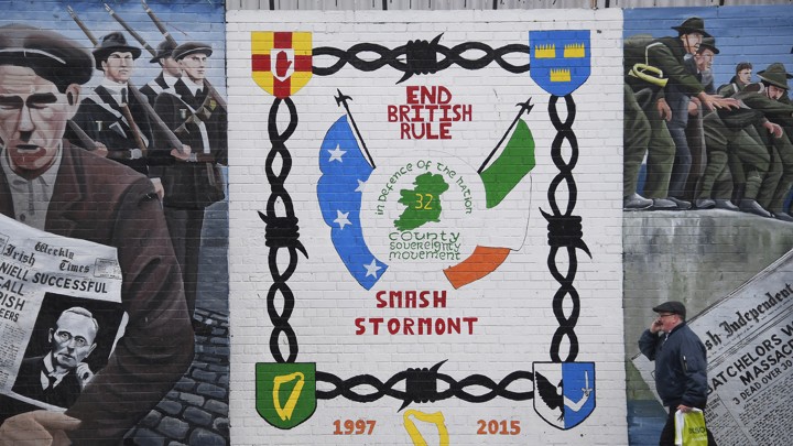 A man walks past a political mural in the Falls Road area of west Belfast, Northern Ireland, on February 28, 2017.