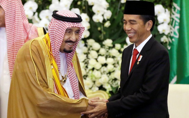 Saudi King Salman shakes hands with Indonesian President Joko Widodo.