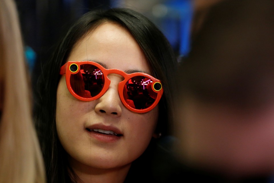 A woman wears bright red Snapchat Spectacles, glasses made by the popular app, on the floor of the New York Stock Exchange, on March 2, 2017.