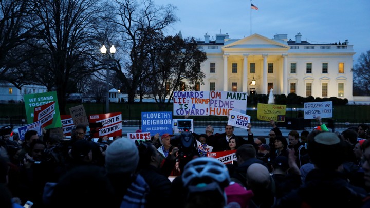 Demonstrators rally against the Trump administration's new travel ban outside of the White House.