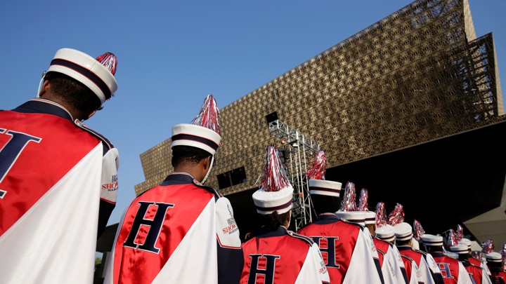 The backs of musicians in front of the grand museum
