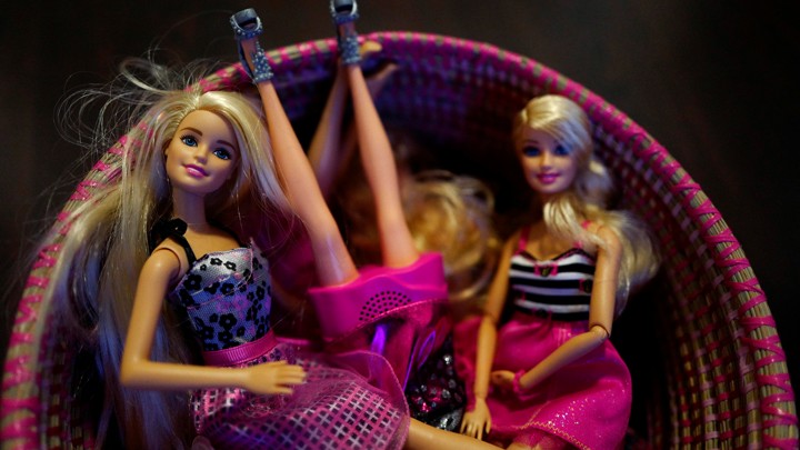 Barbie dolls sit in a basket