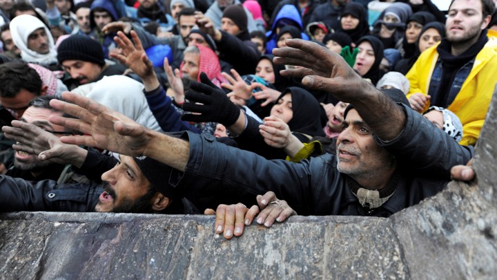 Syrians evacuated from eastern Aleppo reach out for food aid in government-controlled Jibreen area in Aleppo, Syria, on November 30, 2016.
