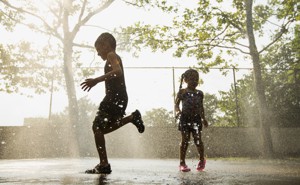 Silhouettes of children running through sprinkles