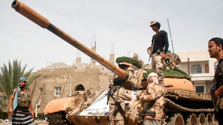Pro-government fighters gather next to a tank they use in the fighting against Houthi fighters in the southwestern city of Taiz, Yemen, on March 22, 2017.