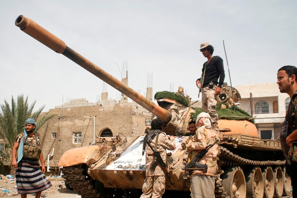 Pro-government fighters gather next to a tank they use in the fighting against Houthi fighters in the southwestern city of Taiz, Yemen, on March 22, 2017.