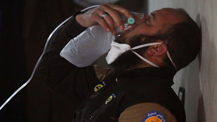 A civil defense member breathes through an oxygen mask, after what rescue workers described as a suspected gas attack in the town of Khan Sheikhoun.