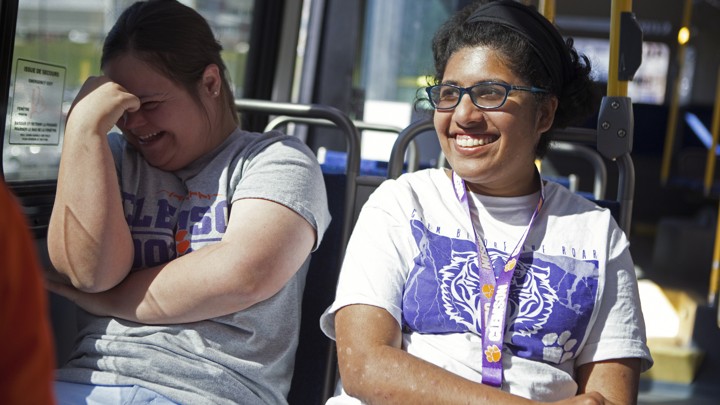 Two women smile on a public bus