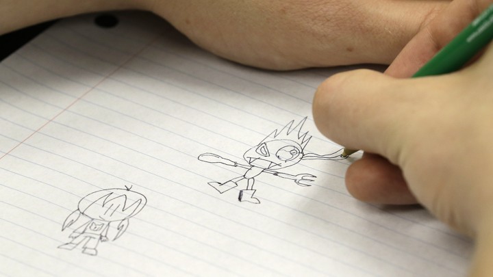 A closeup of a doodle on notebook paper. The cartoon appears to be an angry robot of some sort
