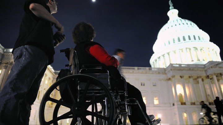 A woman in a wheelchair sits in front of the U.S. Capitol in Washington, D.C.