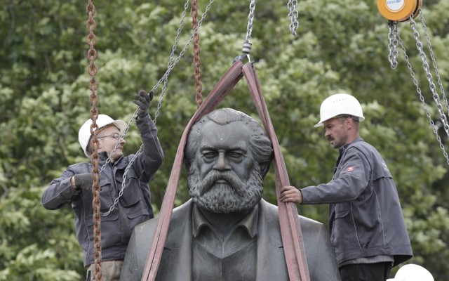 Workers in Berlin attach chains to lift a statue of Karl Marx.