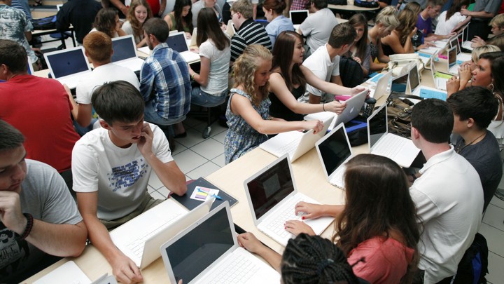 Students sit with Mac laptop computers