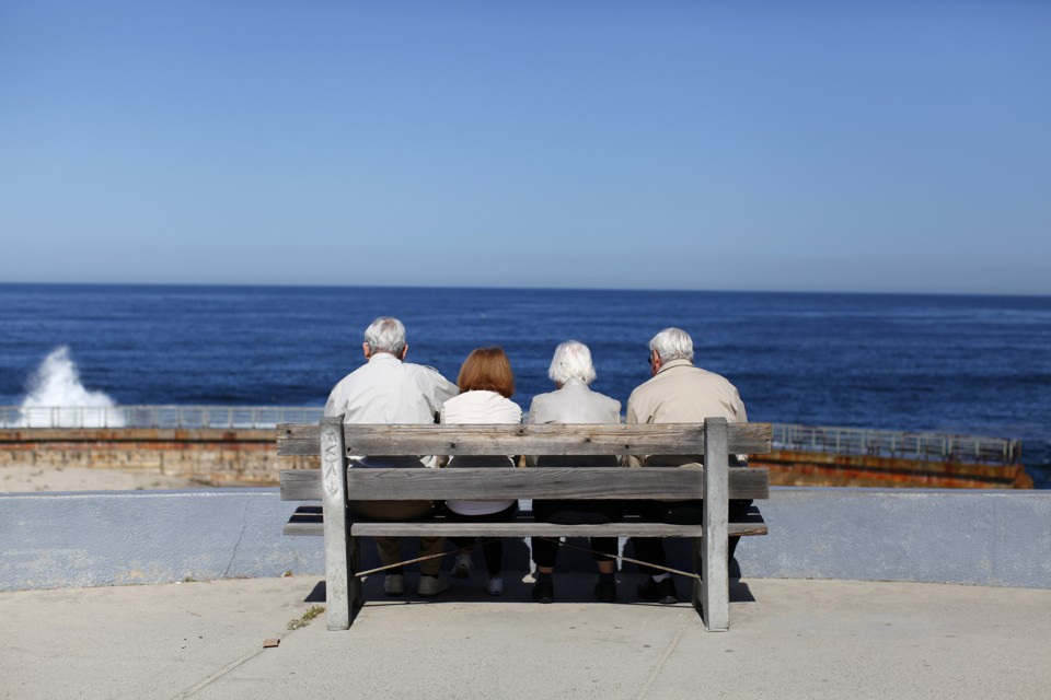 Four elderly people sit on a bench