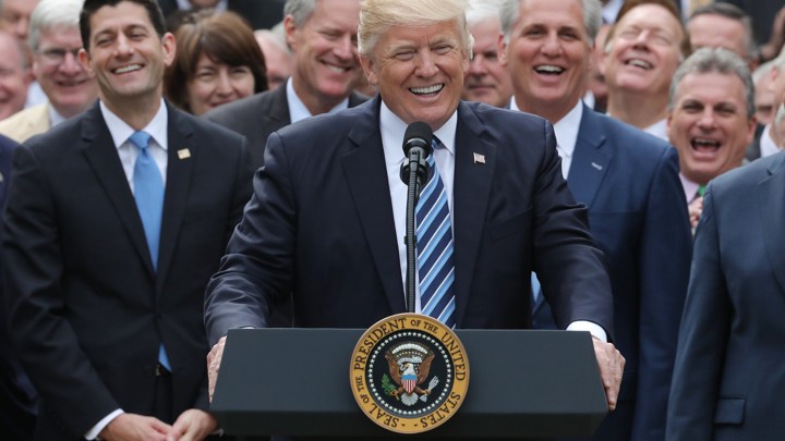 President Donald Trump celebrating in the Rose Garden surrounded by Republican congresspeople