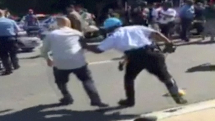 A still image of a police officer chasing a protester during a violent clash outside the Turkish ambassador's residence between in Washington, D.C., on May 16, 2017.
