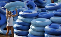 A waterpark employee stacks inner tubes.