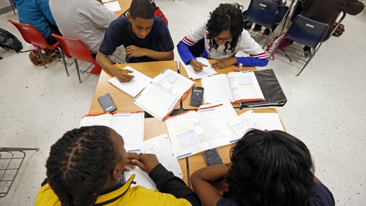 An overhead shot of students with calculators and textbooks
