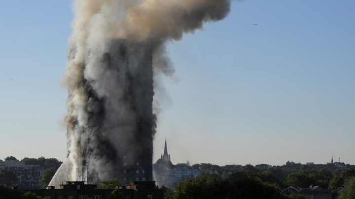 Smoke billows as firefighters deal with a serious fire in a tower block at Latimer Road in West London on June 14, 2017.