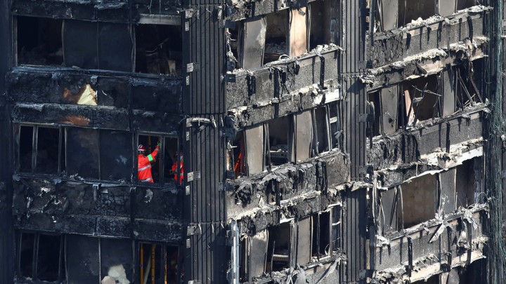 Members of the emergency services work inside burnt out remains of the Grenfell apartment tower on June 18, 2017.