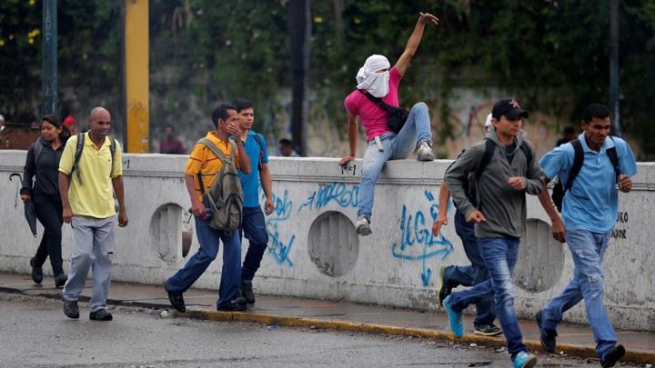 People move to cover as demonstrators rally against Venezuela's President Nicolas Maduro's government in Caracas, Venezuela, on June 28, 2017.