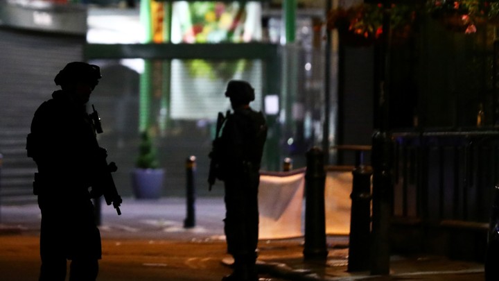 People leave the area with their hands up after an incident near London Bridge in London.