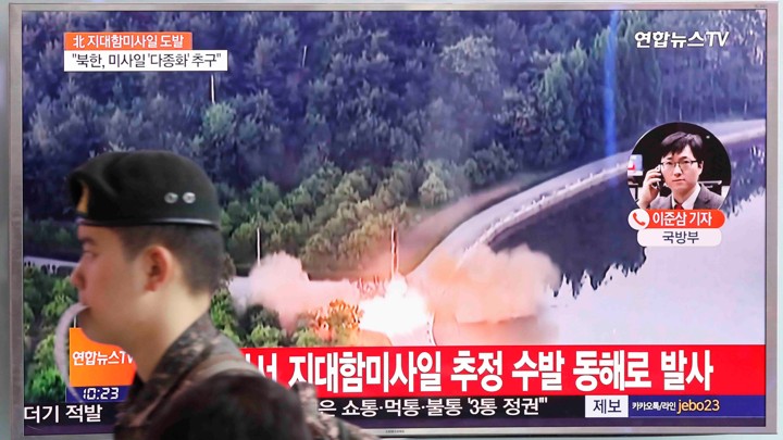 A South Korean soldier walks past a TV broadcast of a news report on North Korea firing what appeared to be several land-to-ship missiles off its east coast, at a railway station in Seoul, South Korea, on June 8, 2017.