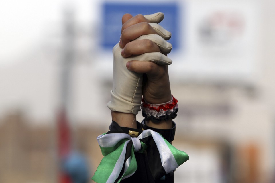 Women clasp hands during a pro-democracy march to demand Yemen's former President Ali Abdullah Saleh stand trial for the killings of protesters who demanded the end of his 33-year rule, in Sanaa April 8, 2013. 