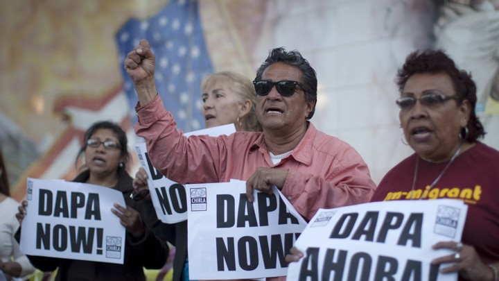Members of the Coalition for Humane Immigrant Rights of Los Angeles hold signs outside a vigil for immigrants at Our Lady Queen of Angels Church on April 16, 2015.
