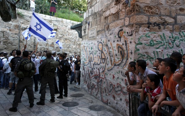 Israeli border policemen secure an alley as Israeli youth march on their way to the Western Wall