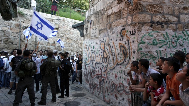 Israeli border policemen secure an alley as Israeli youth march on their way to the Western Wall.