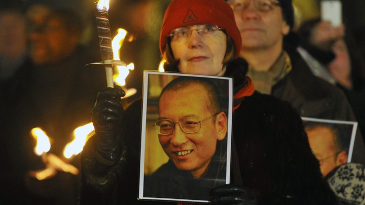 A woman holds a photograph of Xiaobo during a procession in Oslo following the 2010 Nobel Peace Prize ceremony.