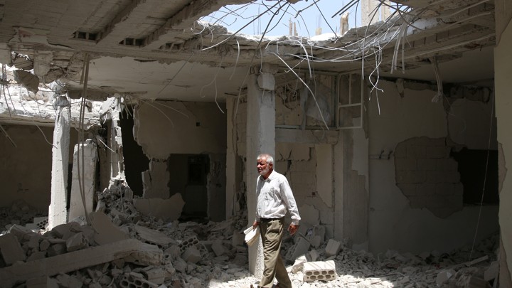A man walks amid rubble at a damaged site in the province of Daraa, Syria.