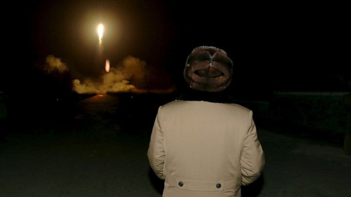 North Korean leader Kim Jong Un watches as a missile takes off.