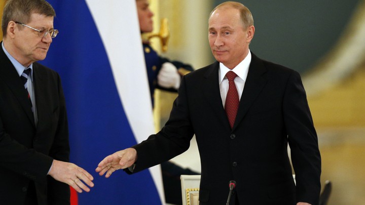 Russian President Vladimir Putin (R) greets Prosecutor General Yury Chaika as he arrives for a meeting with regional officials in the Kremlin in Moscow January 31, 2013.