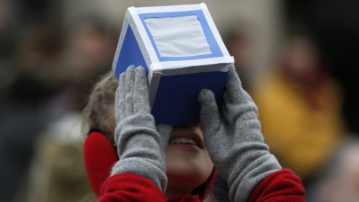 A girl looks through a viewing box.