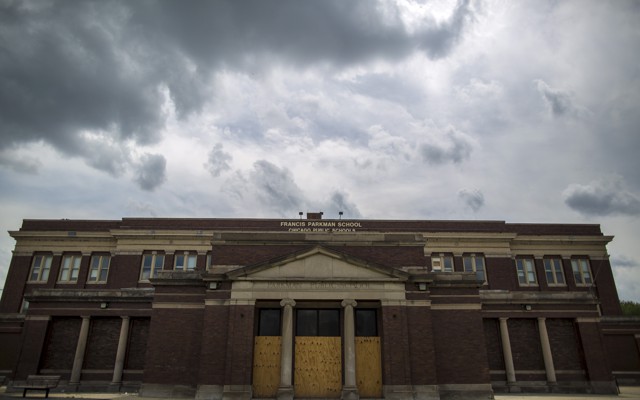 An abandoned, boarded up building in Chicago that two years before this photo was taken housed a school that was later closed