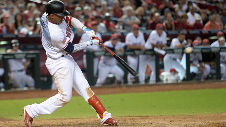 A professional baseball player hits a ball with his bat during the ninth inning.