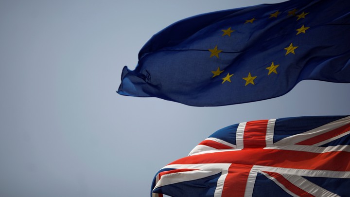 The Union Jack (bottom) and the European Union flag (top) are seen flying.