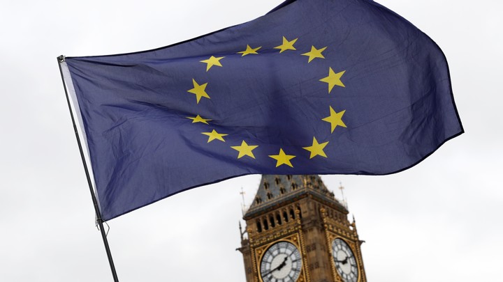 A European Union flag is waved in front of Big Ben outside the Parliament in London on March 28, 2017.