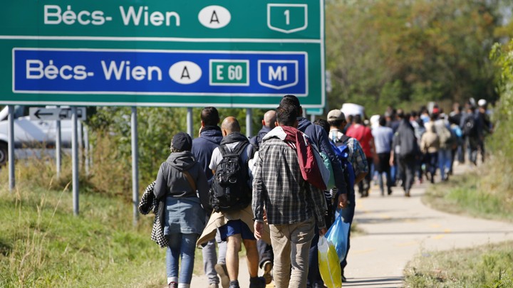 Migrants walk on a road toward the crossing point between Hungary and Austria in Nickelsdorf on September 12, 2015.