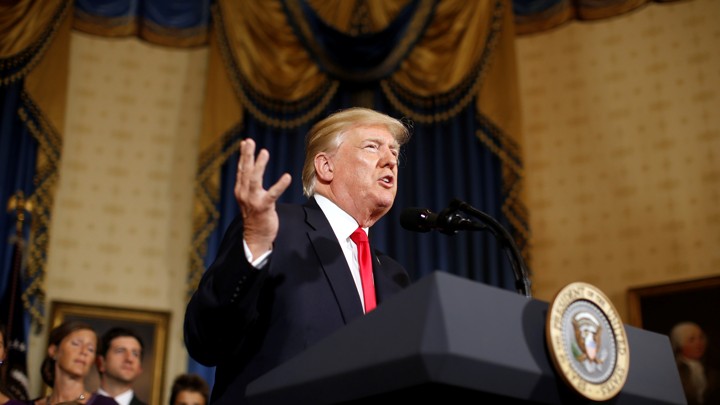President Trump stands at a microphone.