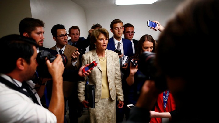 Senator Lisa Murkowski stands with reporters on Capitol Hill.