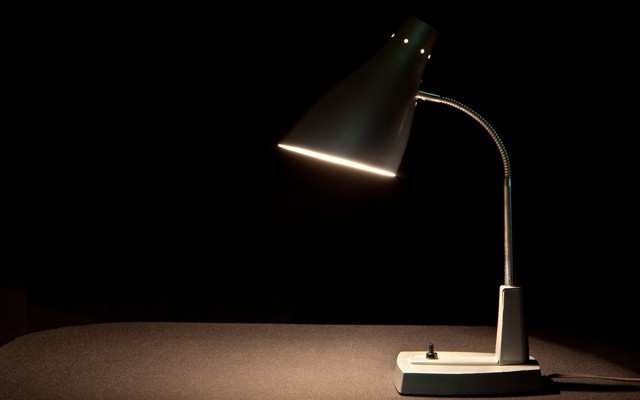 A lamp on a desk against a dark background