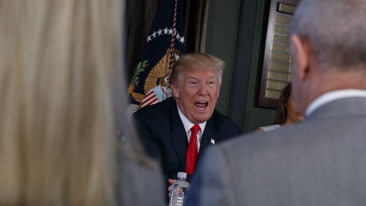 Donald Trump speaks to a table of reporters.