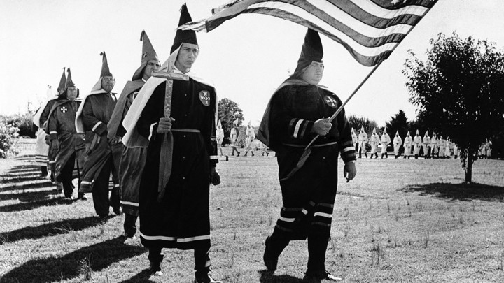 Ku Klux Klan members march in cemetery funeral rites in Chesapeake, Virginia, in 1966.